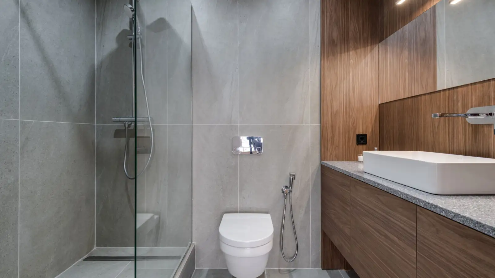 Salle de bain moderne avec douche de plain-pied vitrée, colonne de douche thermostatique, WC suspendu et plan vasque en bois